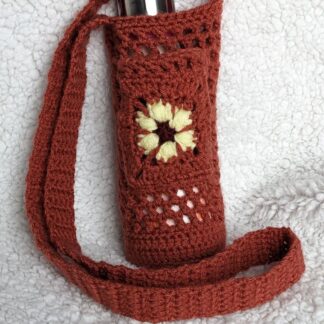 Orange mesh crochet water bottle holder with a yellow flower pocket in the front.